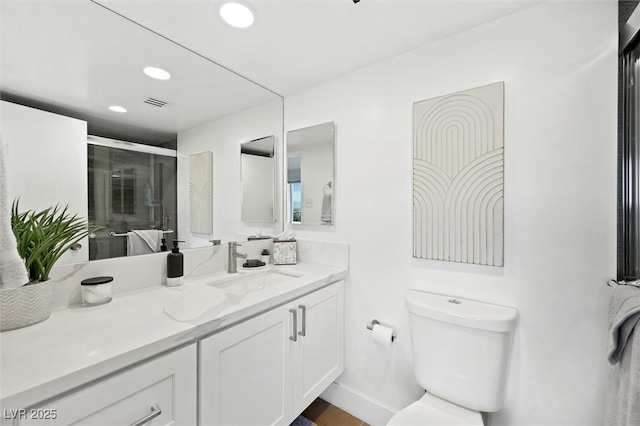 bathroom with walk in shower, vanity, and toilet