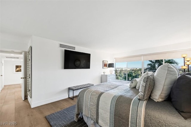 bedroom featuring access to exterior and hardwood / wood-style flooring