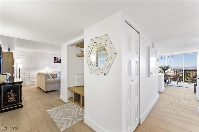 hallway with light hardwood / wood-style floors and a wall of windows