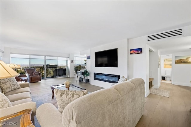 living room featuring a wealth of natural light and light hardwood / wood-style flooring