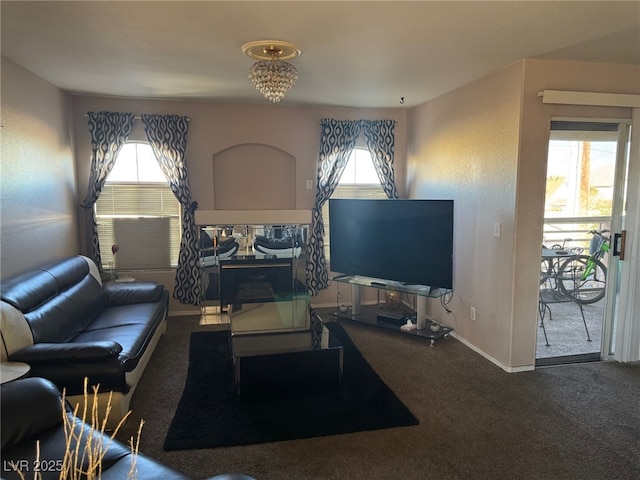 living room with carpet flooring, a healthy amount of sunlight, and an inviting chandelier