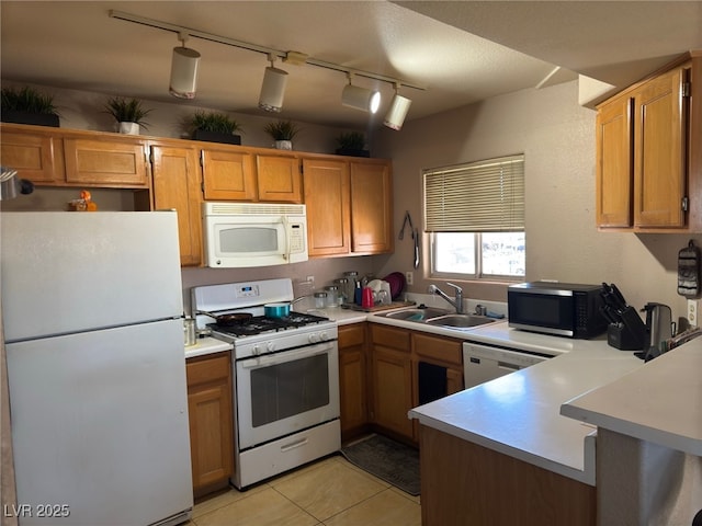 kitchen with sink, light tile patterned flooring, track lighting, and white appliances