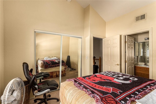 bedroom with carpet, ensuite bath, lofted ceiling, and a closet