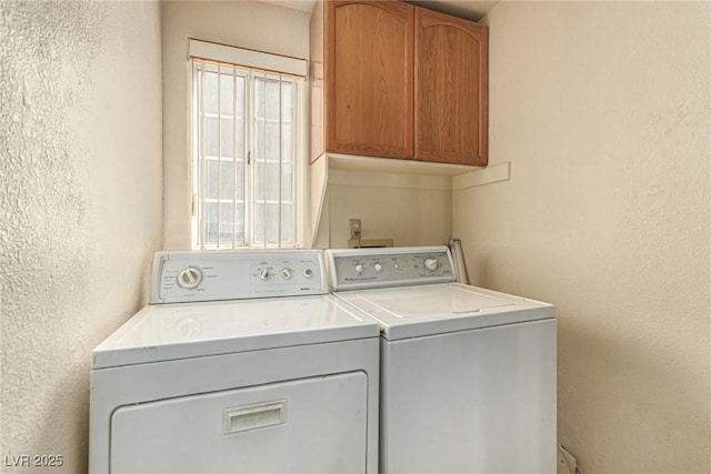 laundry area with washer and clothes dryer and cabinets