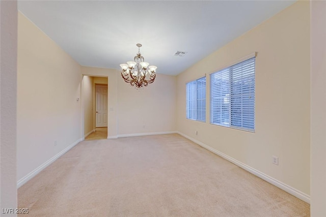 spare room with light colored carpet and a notable chandelier