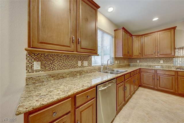 kitchen featuring sink, decorative backsplash, dishwasher, and light stone countertops