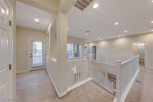 hallway featuring light colored carpet