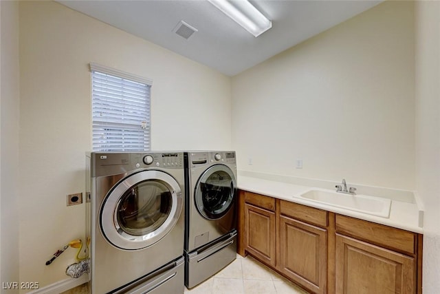 washroom featuring sink, washer and dryer, light tile patterned floors, and cabinets