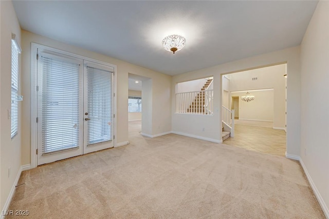 unfurnished room with french doors and light carpet