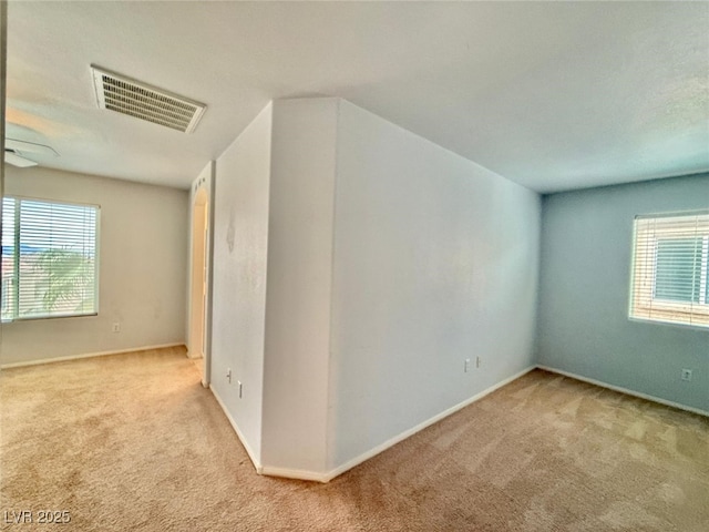 unfurnished room featuring light carpet