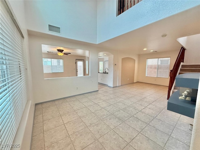 unfurnished living room featuring ceiling fan and light tile patterned floors