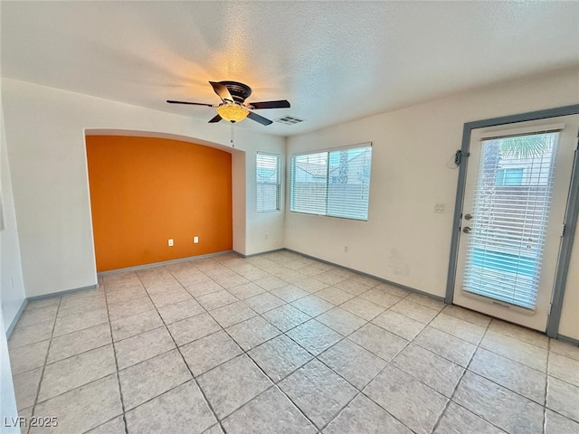 spare room with ceiling fan, light tile patterned floors, and a textured ceiling