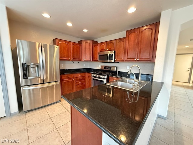 kitchen with light tile patterned flooring, stainless steel appliances, kitchen peninsula, and sink