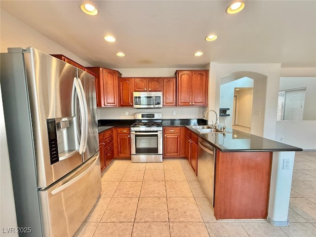 kitchen with sink, kitchen peninsula, stainless steel appliances, and light tile patterned floors