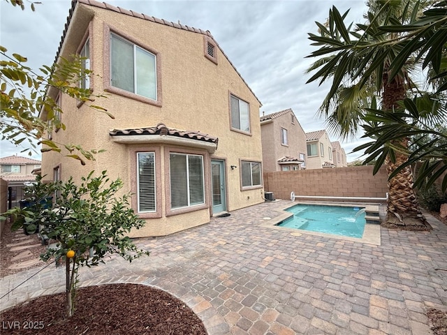 view of swimming pool with pool water feature, cooling unit, and a patio