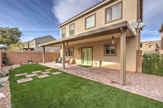 rear view of house with a yard and a patio