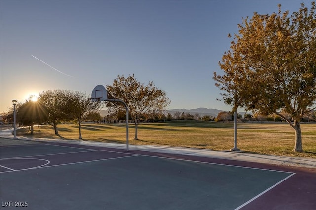 view of sport court featuring a mountain view and a yard