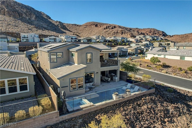 rear view of property featuring a mountain view and a patio area