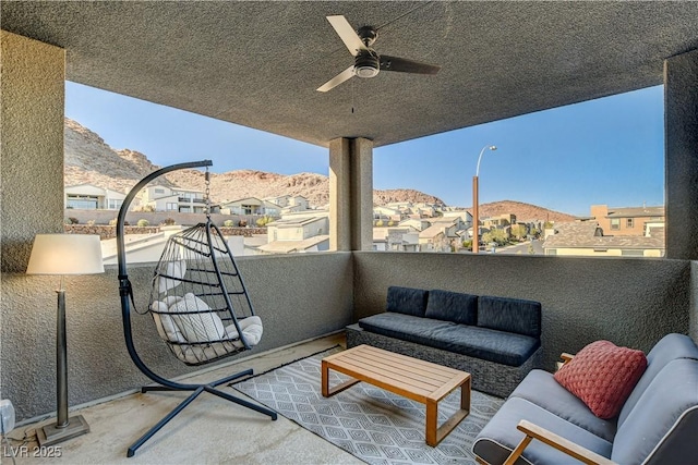 view of patio featuring a mountain view, an outdoor hangout area, a balcony, and ceiling fan