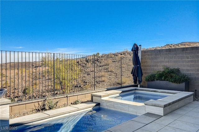 view of swimming pool featuring an in ground hot tub