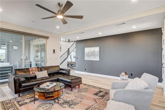 living room with ceiling fan and light hardwood / wood-style flooring