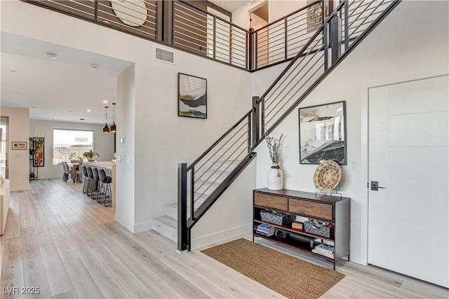 foyer with light hardwood / wood-style flooring and a high ceiling