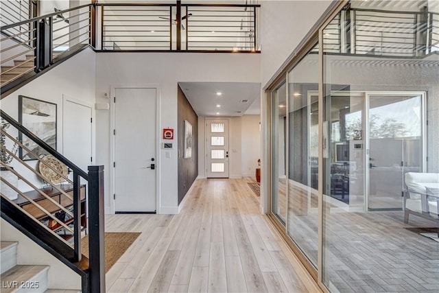 foyer featuring a towering ceiling and light wood-type flooring