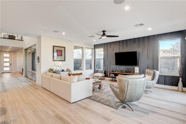 living room featuring light hardwood / wood-style flooring and ceiling fan