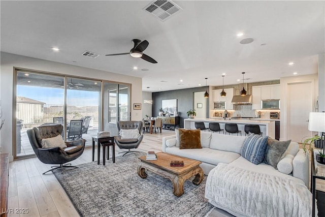 living room featuring ceiling fan and light wood-type flooring