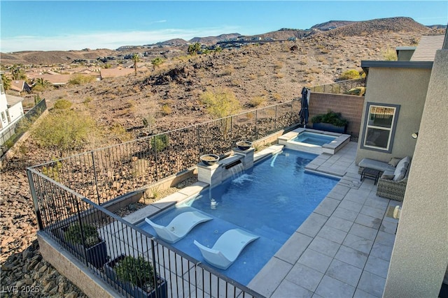 view of pool with an in ground hot tub, pool water feature, a mountain view, and a patio