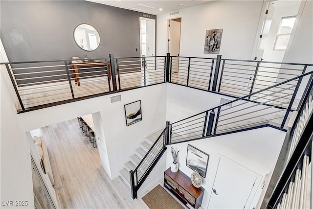 stairs featuring a healthy amount of sunlight and hardwood / wood-style flooring