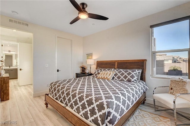 bedroom featuring light wood-type flooring, ceiling fan, and connected bathroom