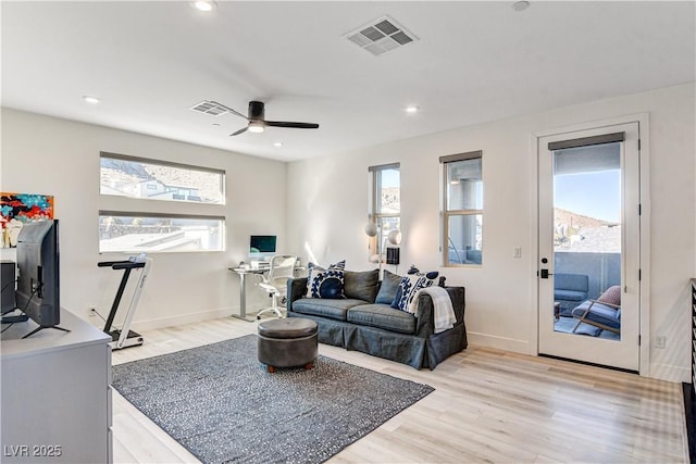 living room with ceiling fan and light wood-type flooring