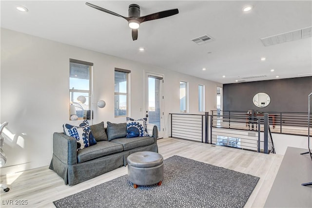 living room featuring ceiling fan and light hardwood / wood-style flooring