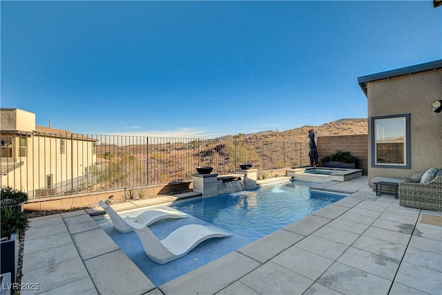 view of swimming pool with pool water feature, a mountain view, an in ground hot tub, and a patio