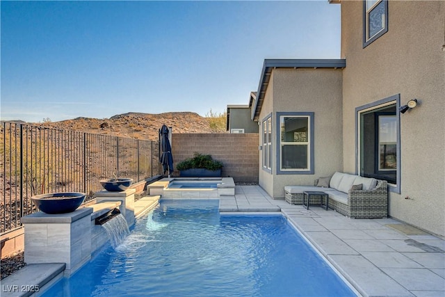 view of swimming pool with pool water feature, a mountain view, a patio area, and an in ground hot tub