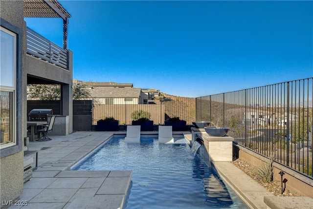 view of swimming pool with a grill, pool water feature, and a patio area