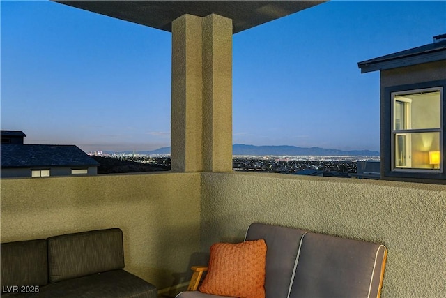 balcony at dusk featuring a mountain view