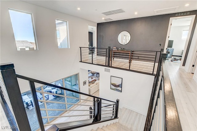 stairs featuring hardwood / wood-style flooring and plenty of natural light