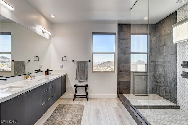 bathroom with a tile shower and vanity