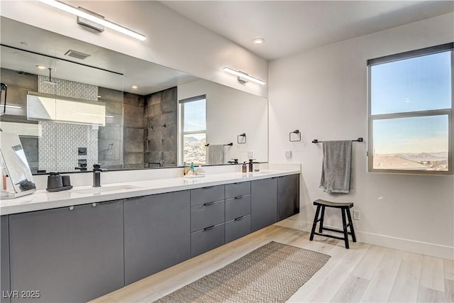 bathroom with wood-type flooring, vanity, and walk in shower