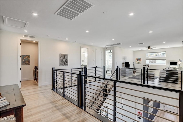 hall featuring plenty of natural light and light hardwood / wood-style floors