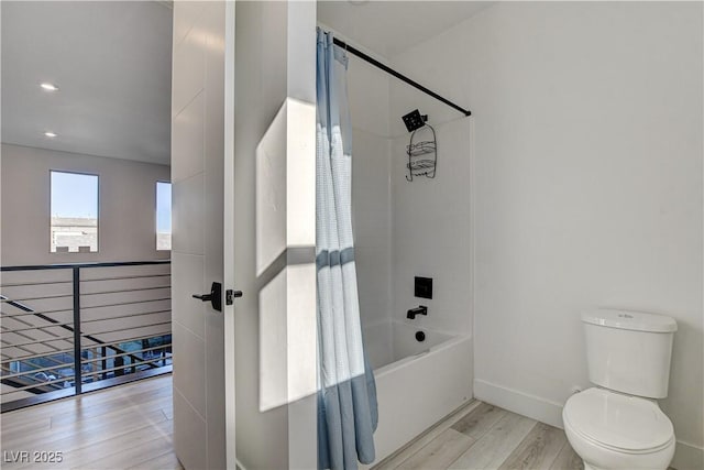 bathroom with hardwood / wood-style flooring, toilet, and shower / bathtub combination with curtain