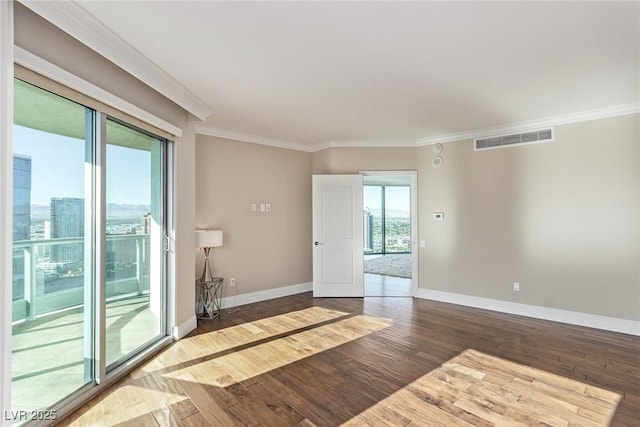 empty room with ornamental molding and hardwood / wood-style floors