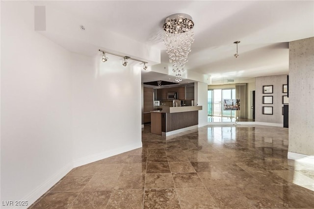 interior space with a notable chandelier and track lighting