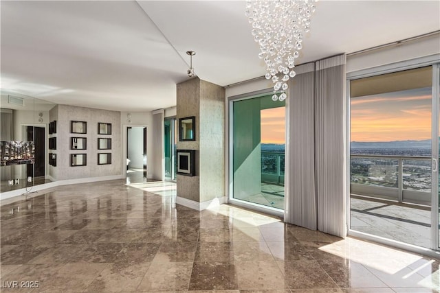 unfurnished living room with a fireplace and a chandelier