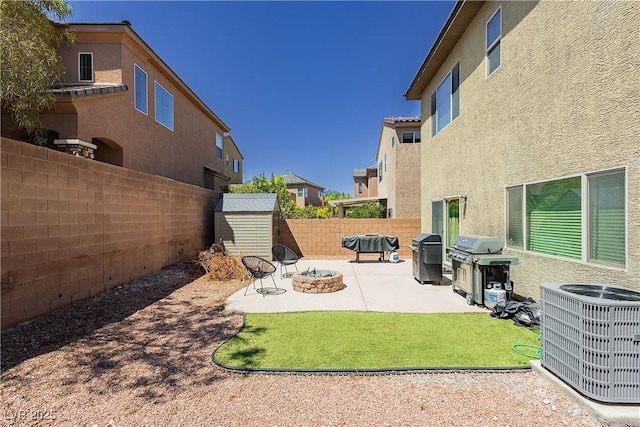 view of yard featuring a storage unit, a patio area, cooling unit, and an outdoor fire pit