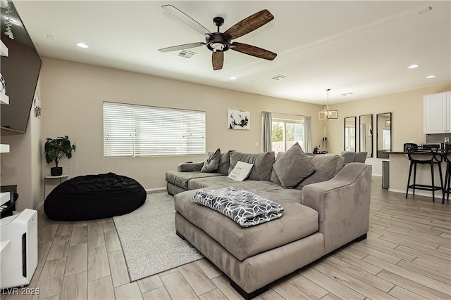 living room with ceiling fan and light hardwood / wood-style floors