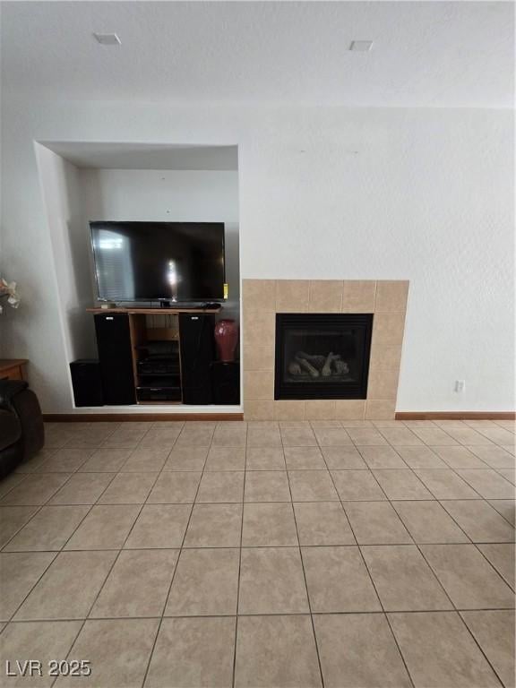 unfurnished living room with light tile patterned floors and a tiled fireplace