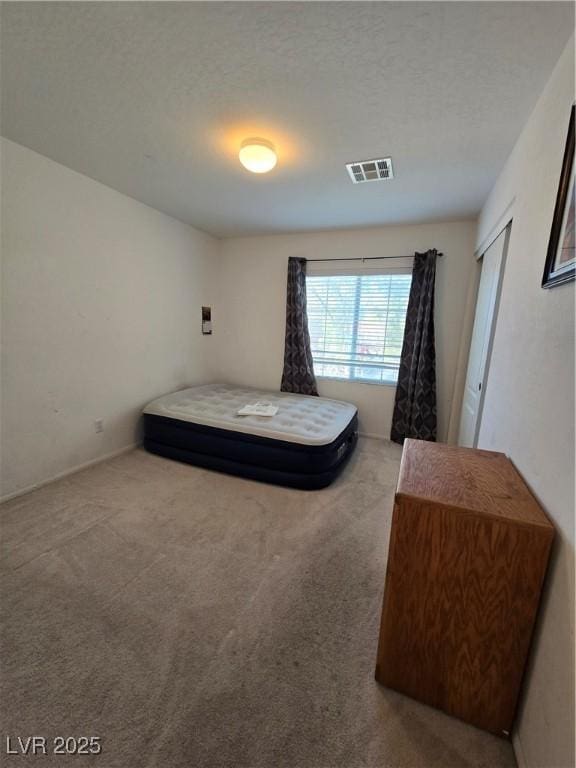 carpeted bedroom featuring a textured ceiling